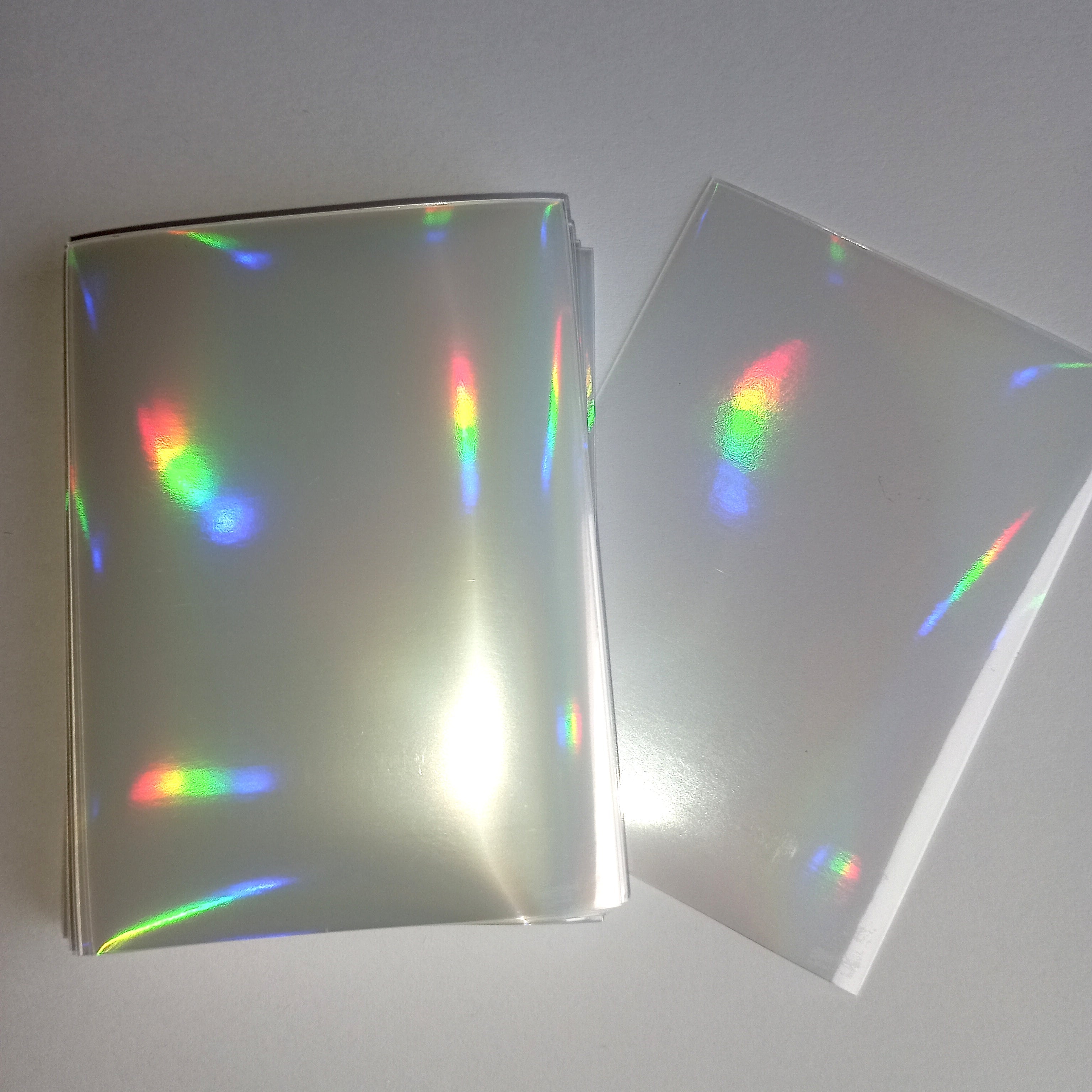 50 vnt. holografinės kortelių įmautės (sleeves) 65×90 mm – Pokémon, MTG, TCG kortelėms Rainbow